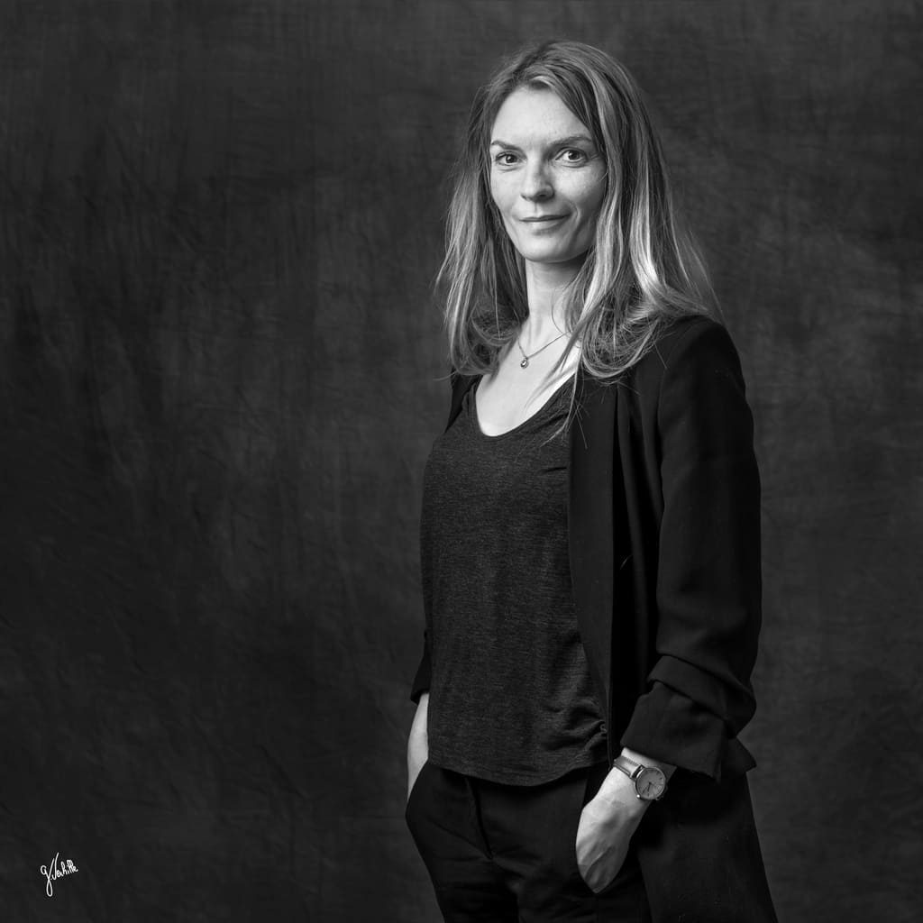Photographe corporate à Marseille – Germain Verhille. Portrait corporate d'une femme sur fond noir, réalisé en noir et blanc au studio photo. Image destinée à illustrer le service de portrait professionnel, tel que : portrait corporate, portrait d'artiste, portrait de métier, ou encore portrait corporate en entreprise ou en extérieur, pour les sociétés souhaitant faire photographier leurs employés au bureau ou sur site.