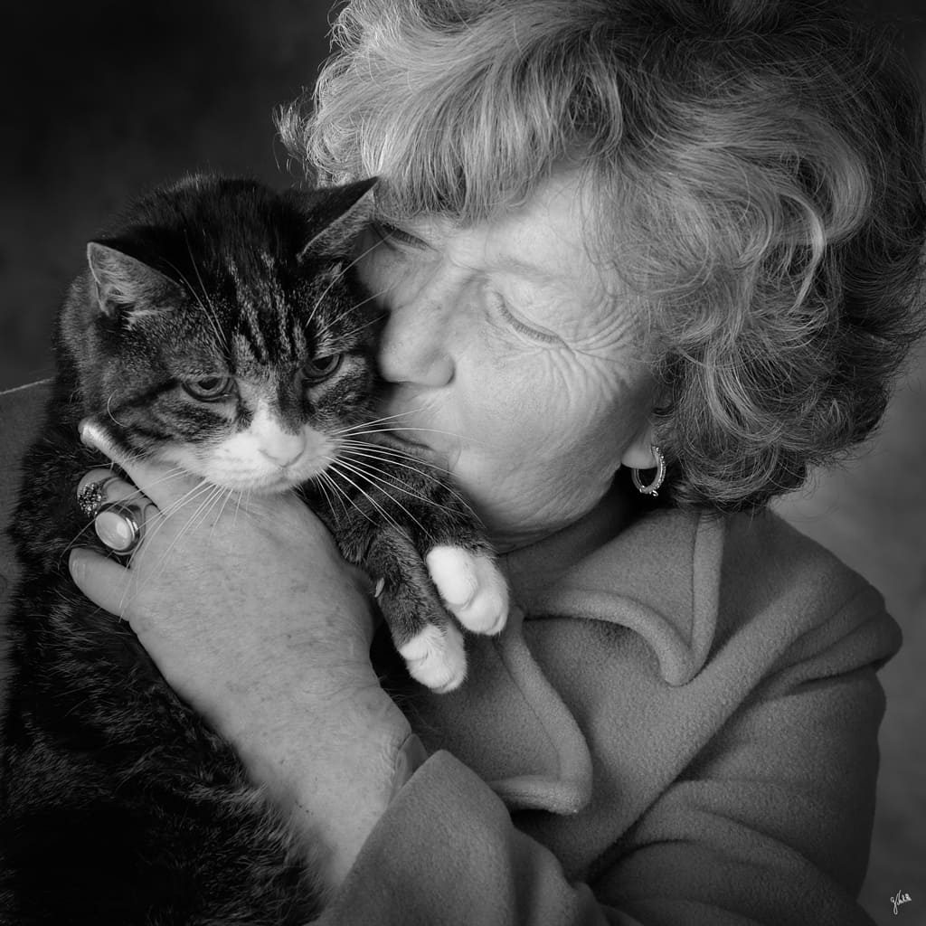 Photographe animalier à Marseille – Portrait en noir et blanc d’une femme embrassant son chat, réalisé en studio. Image illustrant le service de séance photo avec animaux de compagnie, portraits complices et expressifs capturant le lien entre l’humain et son animal. Studio photo spécialisé dans les portraits avec chiens, chats et animaux de compagnie.