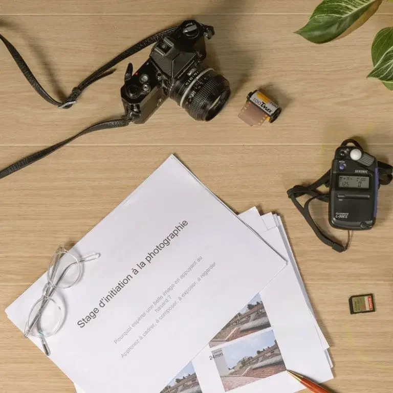 Matériel photo et documents de stage posés sur une table, illustrant les stages photo proposés par Germain Verhille Photographe à Marseille. Ateliers d’initiation à la photographie et cours de perfectionnement adaptés à tous les niveaux, avec approche pédagogique et pratique.