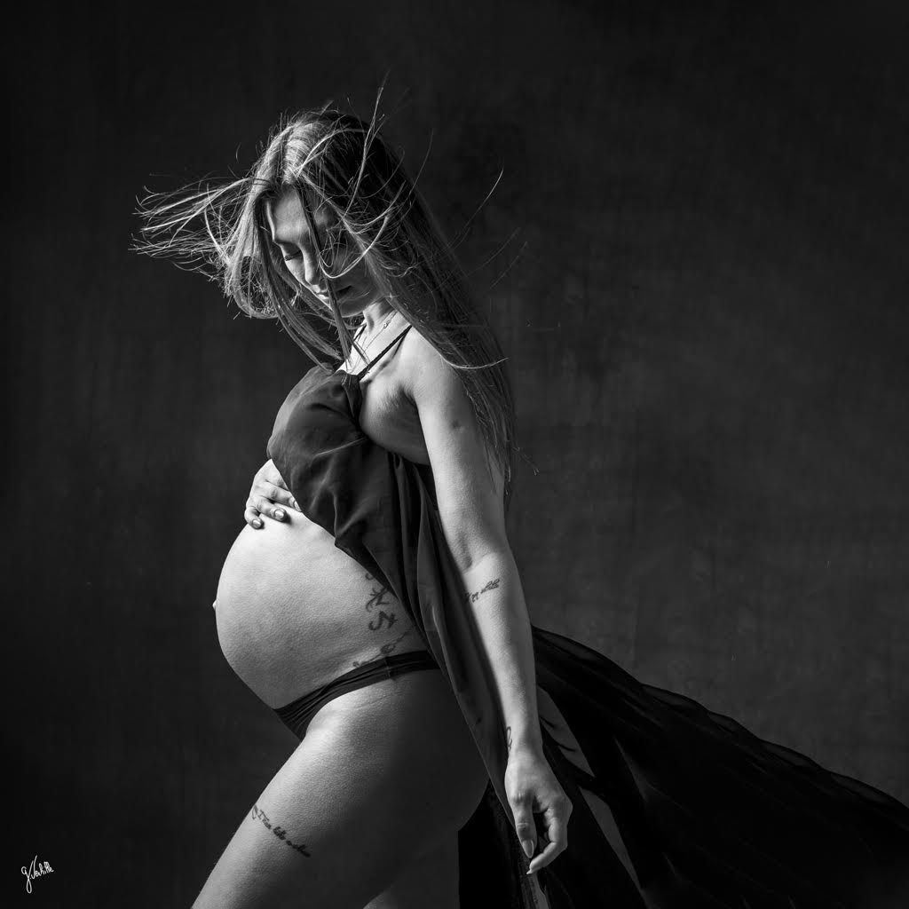 Photographe grossesse à Marseille – Portrait en noir et blanc d’une femme enceinte réalisé en studio. Séance photo de maternité mettant en valeur le ventre rond, la douceur et l’émotion. Shooting photo grossesse professionnel pour immortaliser ce moment unique avec élégance et sensibilité.